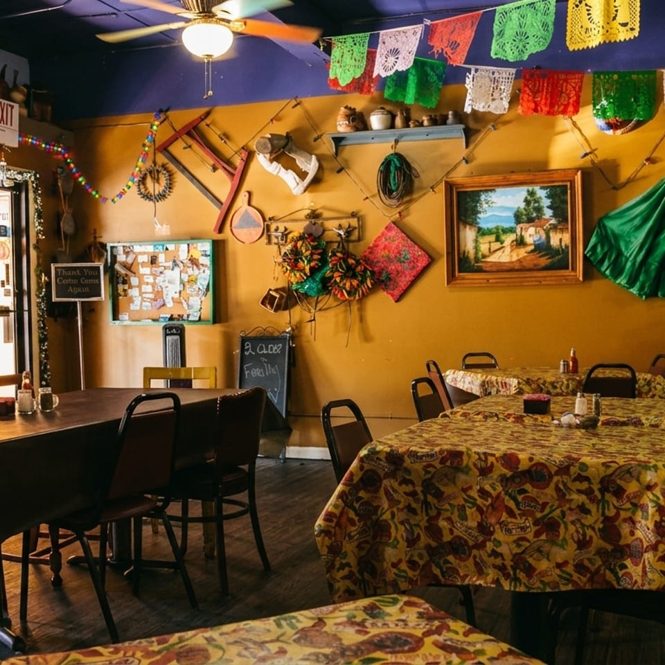 Colorful Mexican restaurant interior with decorated tables, festive banners, and cultural wall art.